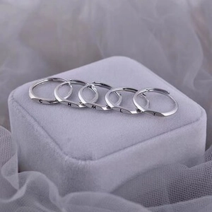 Makroaufnahme von silbernen verstellbaren Ringen mit Gravur auf grauem Samt-Hintergrund