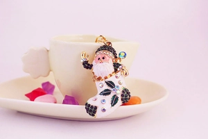 Macro view of Santa Claus in boot keychain with red enamel and sparkling rhinestones