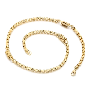 Golden titanium steel spring necklace with round links in a spiral layout on white
