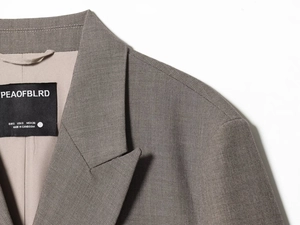 Close-up of grey double-breasted blazer lapel and interior size label detail