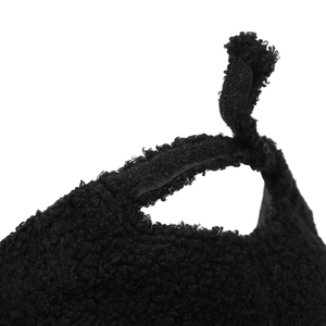 Macro detail of black sherpa baseball cap featuring an adjustable velcro strap closure