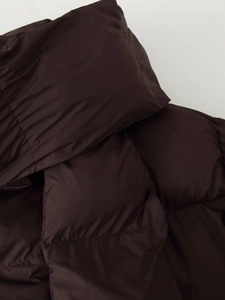Close-up of quilted dark brown down jacket fabric showing high-quality stitching and texture