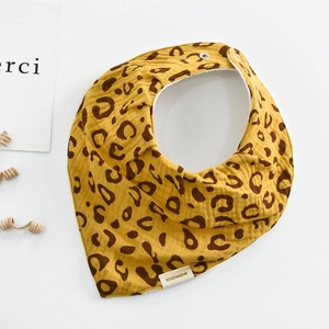 Detail of leopard print cotton baby bib with snap closure and soft muslin texture