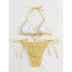 Flat lay of yellow floral triangle bikini set with smocked texture on white plush background