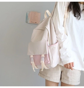 Side view of cream and pink school backpack showing side pockets and buckle straps