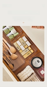 Clear acrylic drawer organizers for makeup brushes and cosmetics in a wooden drawer