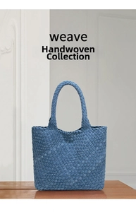 Close-up of the woven denim texture and handcrafted fabric patterns on a blue tote bag