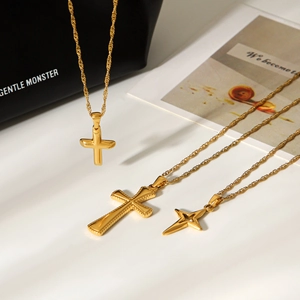 Three 18k gold plated stainless steel necklaces with cross and star pendants on white background