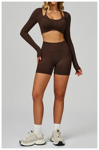 Close-up of brown seamless yoga set featuring long sleeve layered crop top and high waist shorts