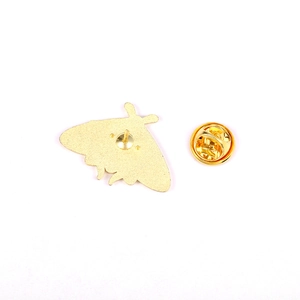 Detail view of the metal butterfly clutch and pin backing on golden insect brooch