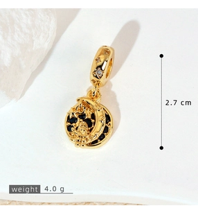 Detail of gold moon and astronaut pendant with micro-paved black stones and star loop