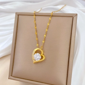 Elegant gold titanium steel necklace with luxury crystal heart pendant on white silk fabric