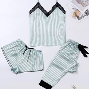 Detailed flat lay of mint green striped silk pajama set with black lace V-neck trim