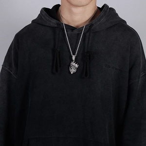 Close-up of a silver hip hop lion head pendant with crown on a twisted rope chain