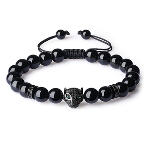 Macro shot of black bead bracelet featuring a detailed leopard head with green eyes