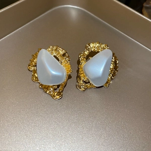 Détail macro de boucles d'oreilles vintage en triangle irrégulier avec perle