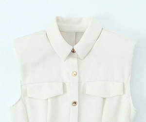 Detail of sleeveless crepe mini dress featuring pointed collar and gold metal buttons