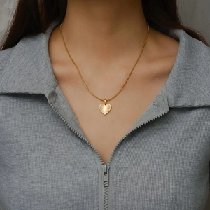 Fashionable 18K gold plated heart pendant necklace on female model neck
