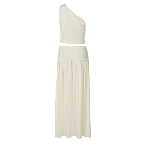 Detail view of cream two-piece set featuring a one-shoulder top and maxi skirt fabric texture