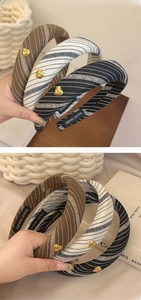 Detail of vintage striped fabric headbands featuring a gold heart charm and soft texture
