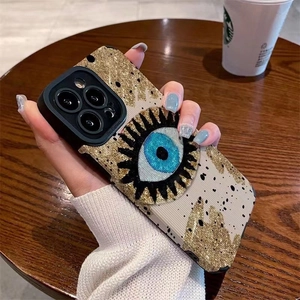 Nordic evil eye patterned iPhone Pro case with gold glitter on off-white striped texture