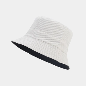 Close-up of white corduroy bucket hat texture with black interior and striped fabric detail