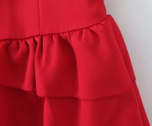 Detailed macro view of layered ruffle tiers on a red sleeveless tiered cake dress