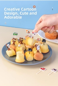 Close-up of cute cartoon animal and vehicle food picks on a cake in a blue plate