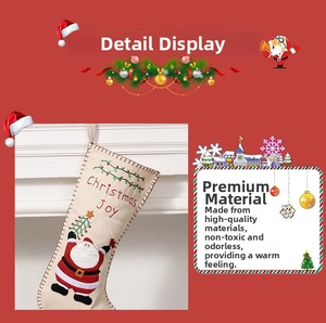 Detail of embroidered Christmas Joy stocking with 3D Santa Claus on rustic burlap fabric