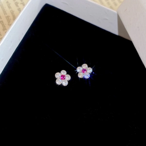 Detail von Blumenohrringen mit rot-violettem Kristall und Zirkon in schwarzer Box
