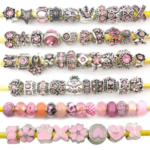 Detail of silver and pink DIY charm beads with floral and heart shapes on display rods