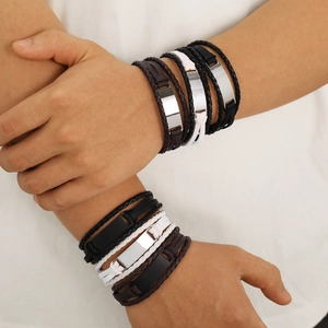 Multi-layer braided leather bracelets with engraved metal plates on male model's wrist