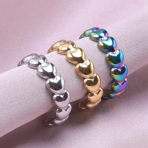 Close-up of heart-shaped stainless steel rings in silver gold and rainbow finishes