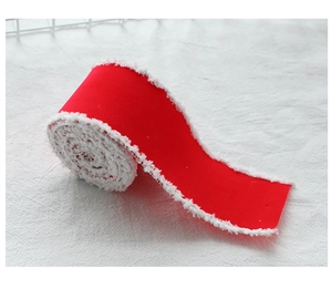 Close-up of red velvet Christmas ribbon with white plush trim for gift wrapping