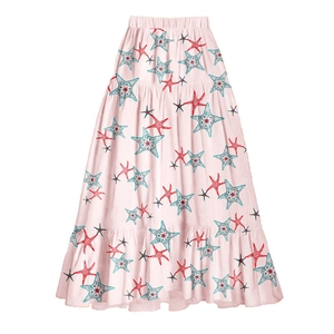 Detail of high-waist maxi skirt featuring colorful starfish print on light pink fabric