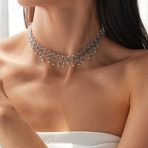 Macro detail of bohemian silver choker necklace with delicate beaded chain on a female model