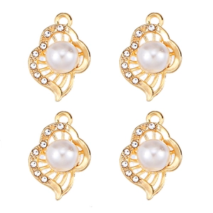 Detail of four golden alloy heart pendants with pearls and rhinestones for DIY jewelry