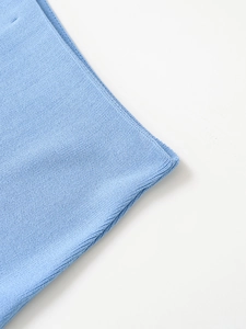 Close-up of fine stitching and light blue denim fabric texture on hooded jacket