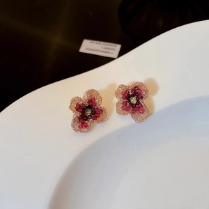 Detailed view of handcrafted beaded flower earrings with red and champagne crystals