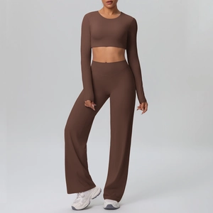 Detail of high-stretch crop top and wide-leg yoga pants in dark brown fabric