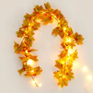 Close-up of maple leaf string lights with warm LED glow for autumn home decoration