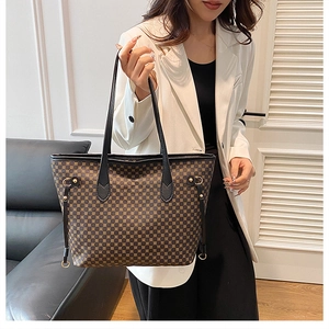 Detail of dark brown tote bag featuring geometric patterns and side drawstring closure