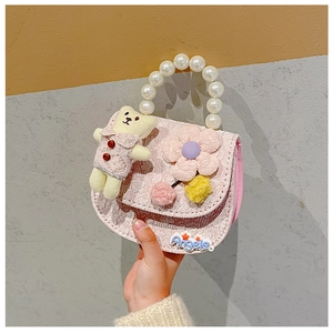 Detailed shot of pink fabric girl's purse with pearl handle and cute teddy bear charm