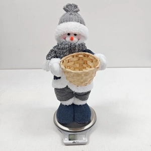 Detail of plush snowman ornament with grey knitted hat weighing 391g on a scale
