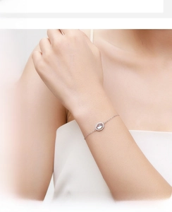 Close-up of elegant S925 silver bracelet with moonstone pendant on model wrist