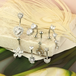 Detailed close-up of stainless steel belly rings with zircon inlays on white stones