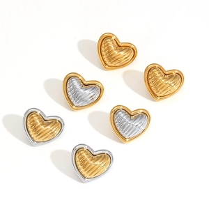 Detail of two-tone heart stud earrings with textured wavy patterns in gold and silver