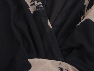 Détail du décolleté en V sexy sur robe en maille noire avec imprimé abstrait