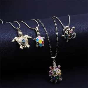 Detail view of colorful turtle pendant necklaces with zircon inlay and gold finish