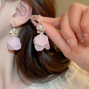 Close-up of elegant pink petal earrings with crystal accents worn by a model
